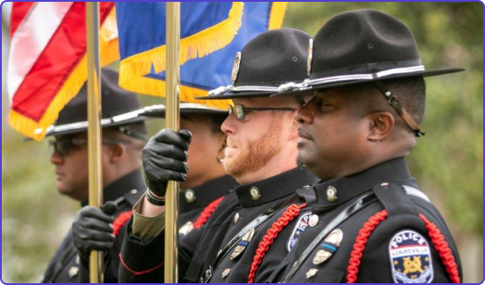4 Police officers holding flags at a cereony