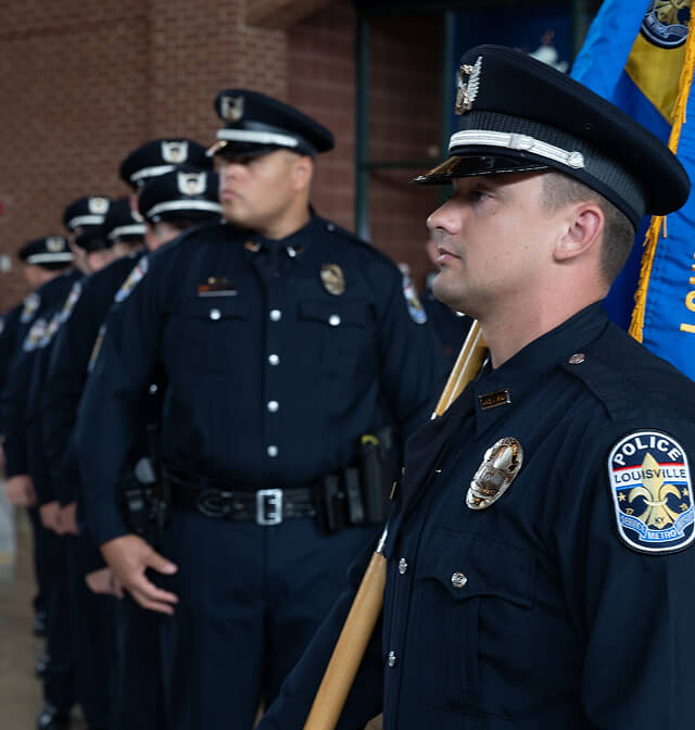 Police officers in uniform holding a flag